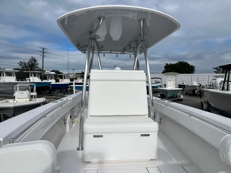 Slide: The Image of 2023 Contender 30T boat with T-top, white seating, and spacious deck in a marina setting. - 18