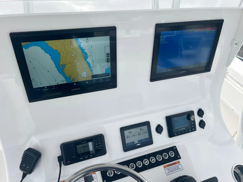 Slide: The Image of 2023 Contender 30T boat dashboard with navigation screens and controls. - 21