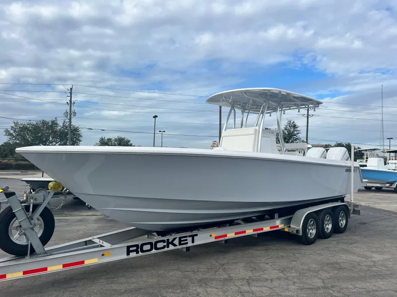 Slide: The Image of 2023 Contender 30T boat on a Rocket trailer, parked outdoors under a cloudy sky. - 3