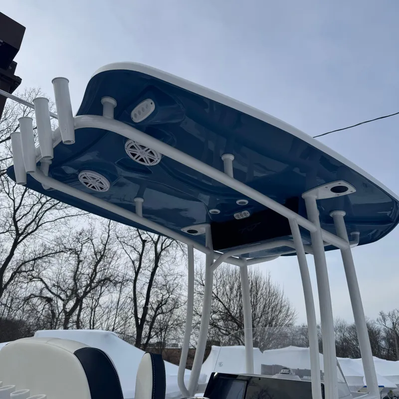 Slide: The Image of Tidewater 220 LXF 2025 boat with blue T-top and rod holders, under a cloudy sky. - 10