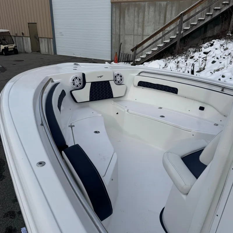 Slide: The Image of 2025 Tidewater 220 LXF boat interior with white and navy seating, docked near snowy area. - 11