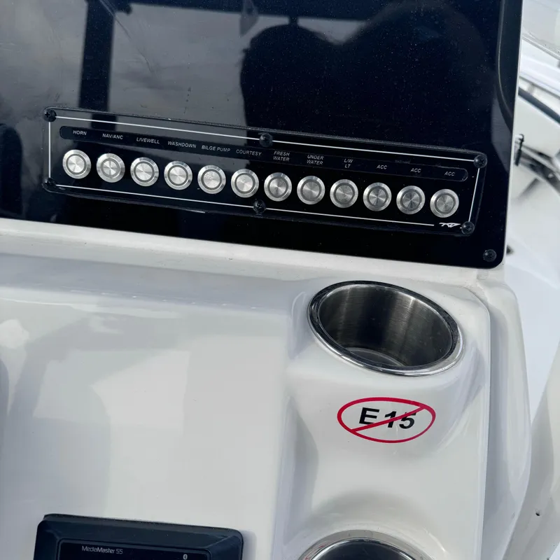 Slide: The Image of Control panel of 2025 Tidewater 220 LXF boat with cup holders and E15 warning. - 22