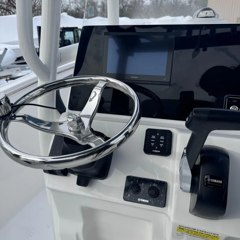 Slide: The Image of 2025 Tidewater 220 LXF boat dashboard with steering wheel and Yamaha controls. - 24