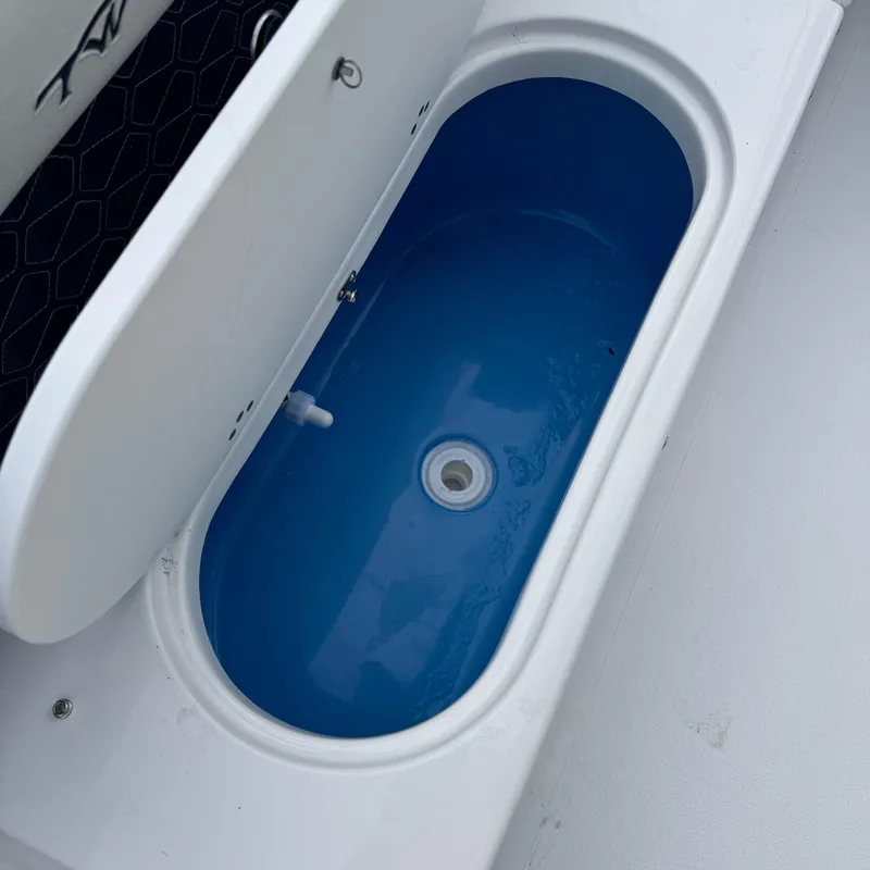 Slide: The Image of Livewell compartment in 2025 Tidewater 220 LXF boat, featuring a blue interior. - 27