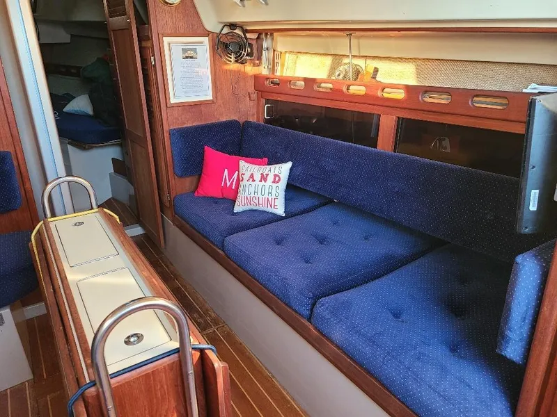 Slide: The Image of Interior of 1985 O'Day 35 sailboat with blue seating and decorative pillows. - 11