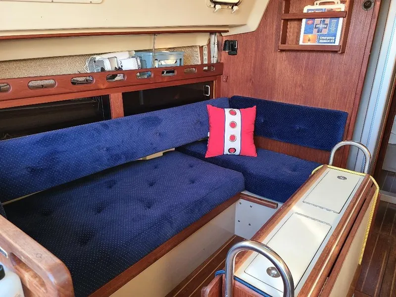 Slide: The Image of Interior of 1985 O'Day 35 sailboat with blue seating and red decorative pillow. - 12