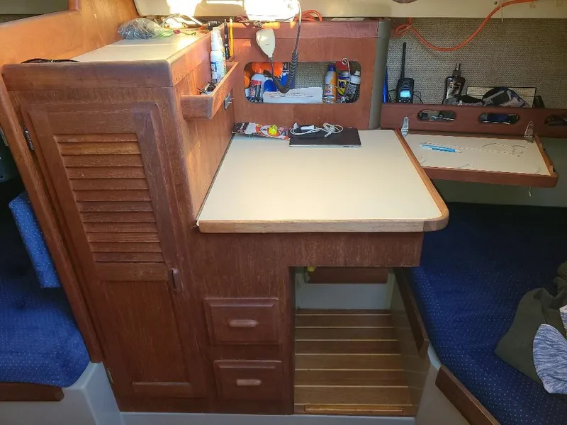 Slide: The Image of 1985 O'Day 35 sailboat interior with wooden cabinetry and navigation station. - 17