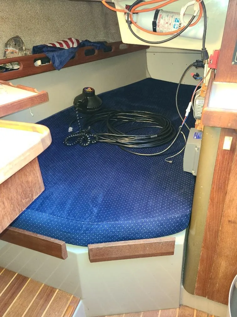 Slide: The Image of Interior cabin of a 1985 O'Day 35 sailboat with blue upholstery and wooden accents. - 19
