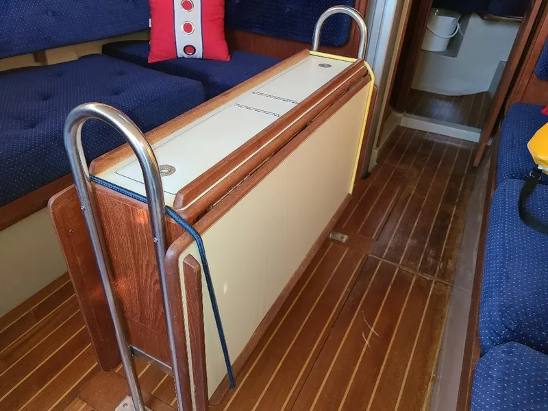 Slide: The Image of Interior of a 1985 O'Day 35 sailboat with wooden flooring and blue seating. - 23