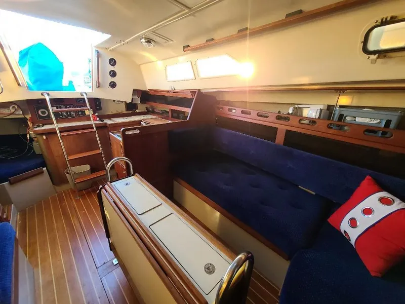 Slide: The Image of Interior of a 1985 O'Day 35 sailboat with blue seating and wooden accents. - 25