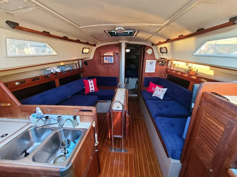 Slide: The Image of Interior of a 1985 O'Day 35 sailboat with cozy seating and wooden finishes. - 26