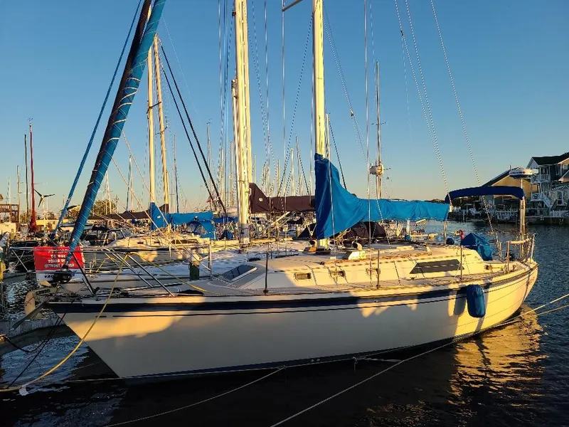 Slide: The Image of 1985 O'Day 35 sailboat docked at marina during sunset, with blue sail covers. - 32
