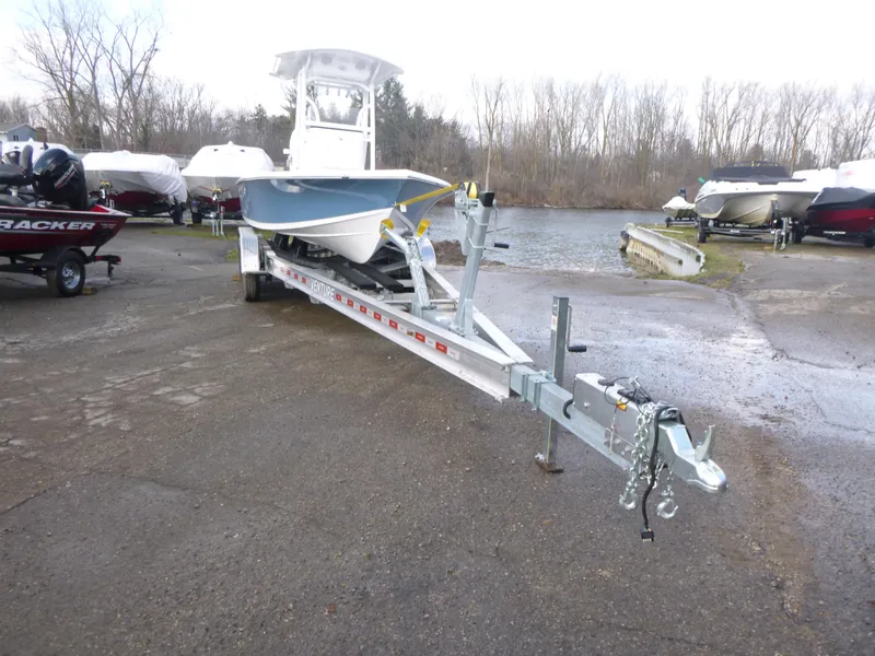 Slide: The Image of 2025 Sea Pro 230 Bay boat on trailer in parking lot under clear blue sky. - 1