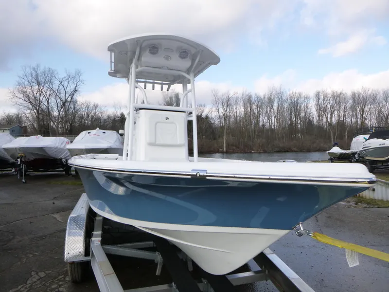 Slide: The Image of 2025 Sea Pro 230 Bay boat on trailer in parking lot, clear blue sky. - 2