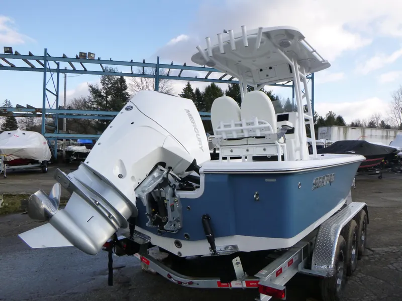 Slide: The Image of 2025 Sea Pro 230 Bay boat deck with storage compartments, shown on a trailer. - 7