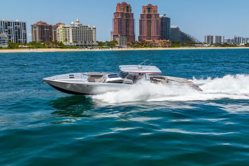 Slide: The Image of 2018 Nor-Tech 560 Sport Center Console cruising on ocean near city skyline. - 18