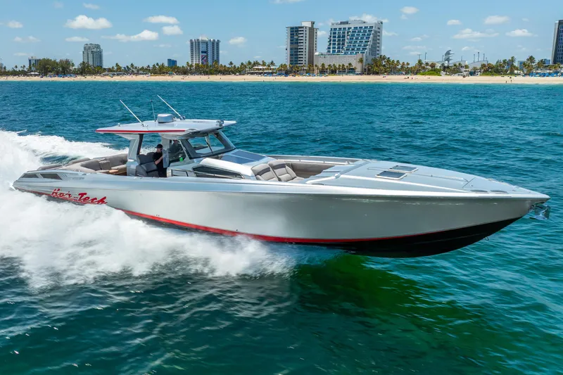 Slide: The Image of 2018 Nor-Tech 560 Sport Center Console cruising on ocean near city skyline. - 2