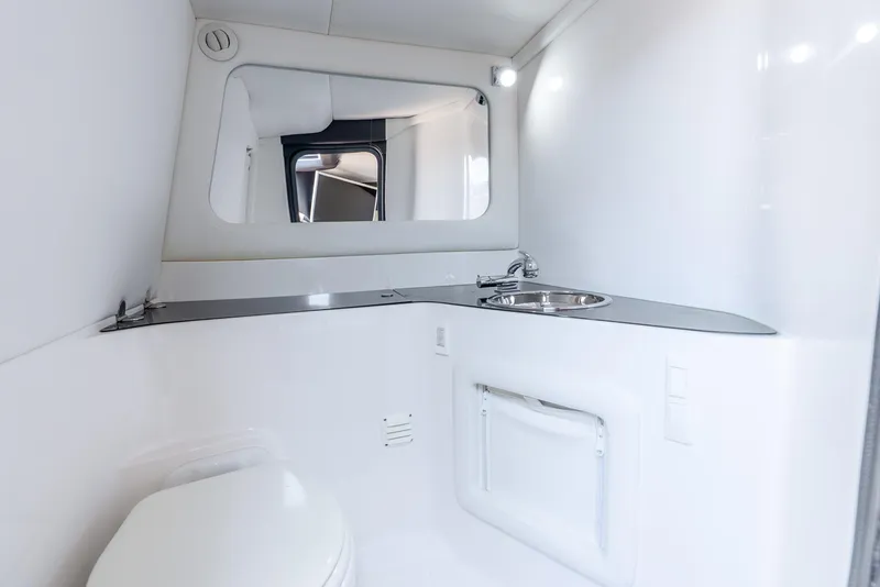 Slide: The Image of Interior of 2018 Nor-Tech 560 Sport Center Console, featuring a sleek white bathroom. - 32