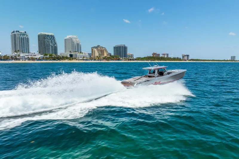 Slide: The Image of 2018 Nor-Tech 560 Sport Center Console cruising near city skyline on blue ocean. - 4