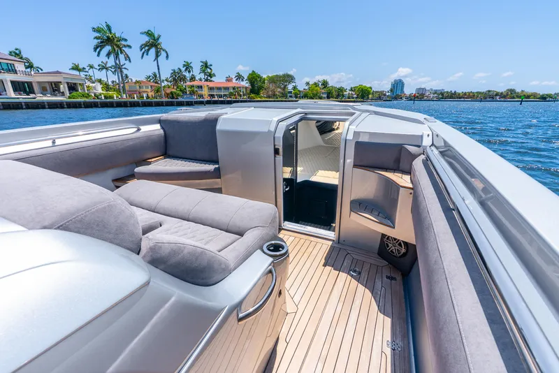 Slide: The Image of 2018 Nor-Tech 560 Sport Center Console boat with luxurious seating on a sunny waterfront. - 40