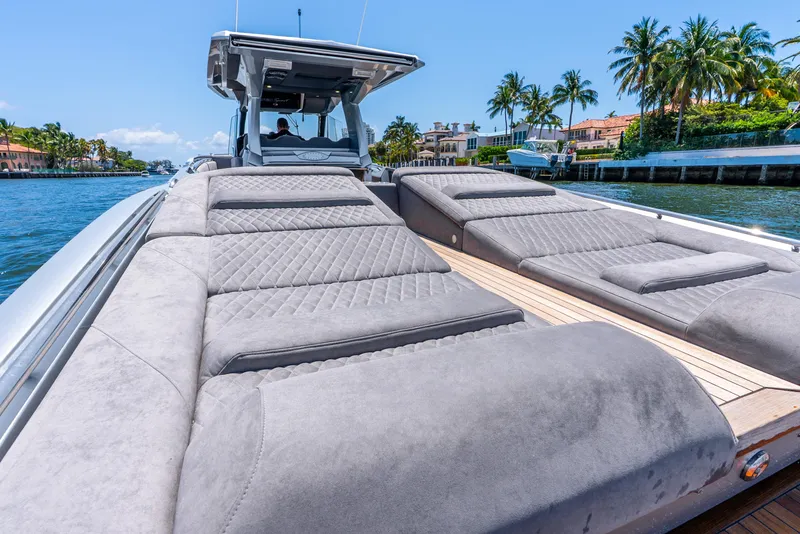 Slide: The Image of 2018 Nor-Tech 560 Sport Center Console with luxurious sunbathing area, docked near palm trees. - 46