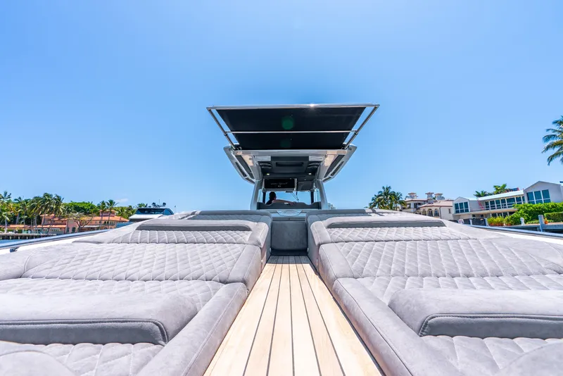 Slide: The Image of 2018 Nor-Tech 560 Sport Center Console with luxurious deck and seating under clear blue sky. - 47