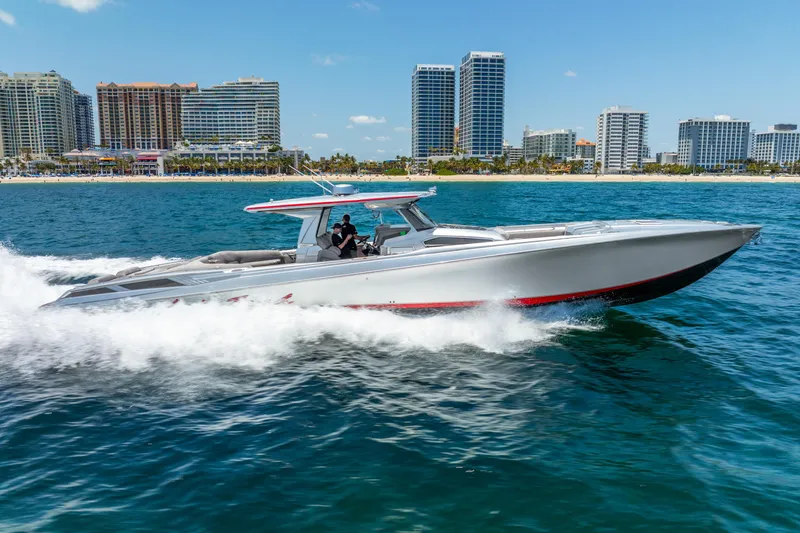 Slide: The Image of 2018 Nor-Tech 560 Sport Center Console cruising on blue ocean near city skyline. - 7