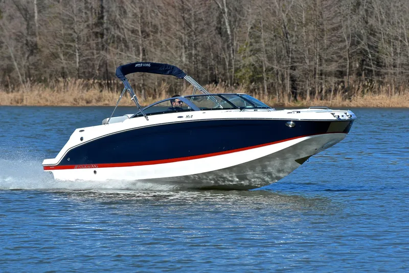 Slide: The Image of 2021 Four Winns HD3 boat cruising on a lake with forested background. - 1