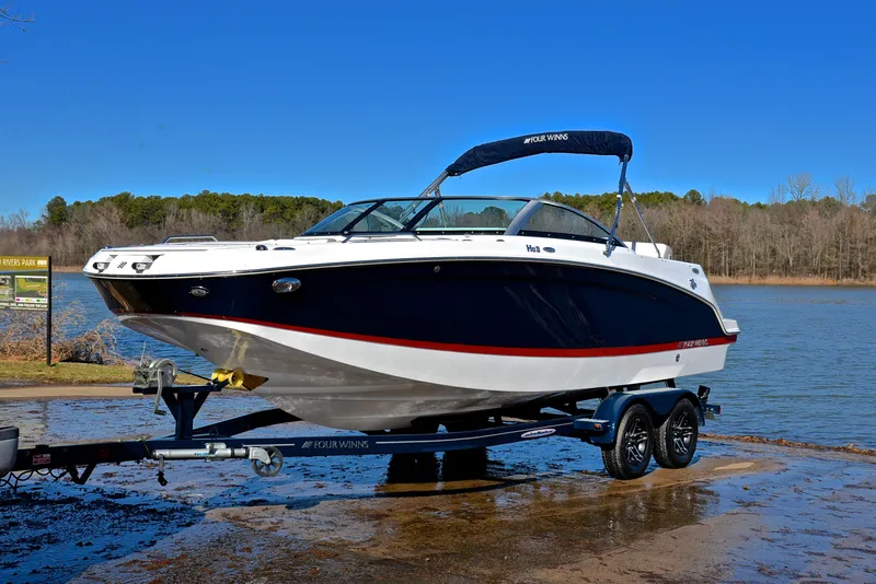 Slide: The Image of 2021 Four Winns HD3 boat on trailer by a lake. - 10
