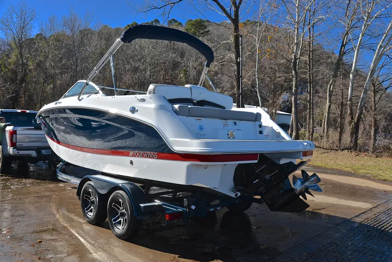Slide: The Image of 2021 Four Winns HD3 boat on trailer, parked outdoors near trees. - 12