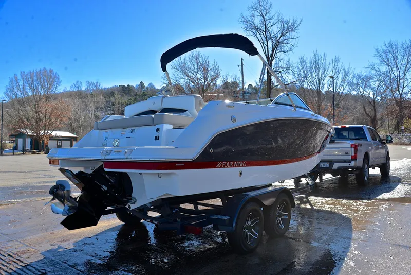 Slide: The Image of 2021 Four Winns HD3 boat on trailer, parked outdoors on a sunny day. - 14