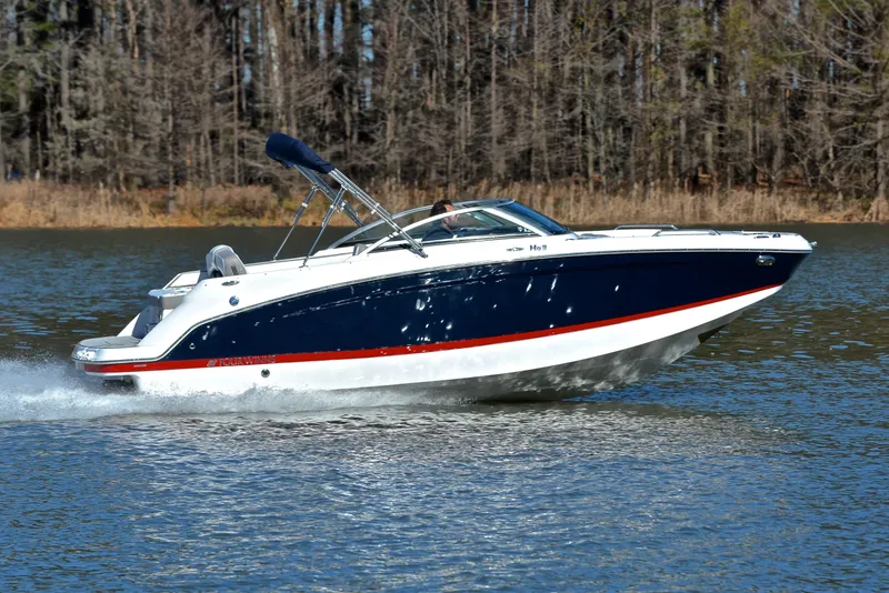 Slide: The Image of 2021 Four Winns HD3 boat cruising on a lake with forest background. - 3
