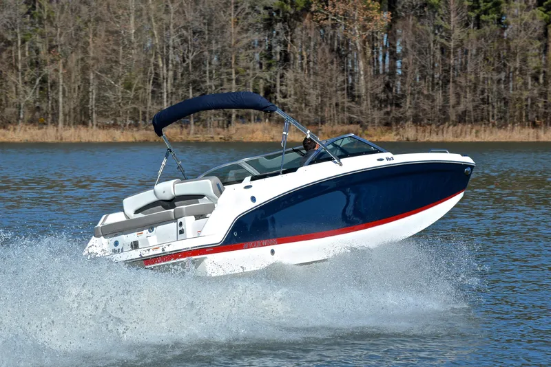 Slide: The Image of 2021 Four Winns HD3 boat cruising on a lake with forested background. - 5