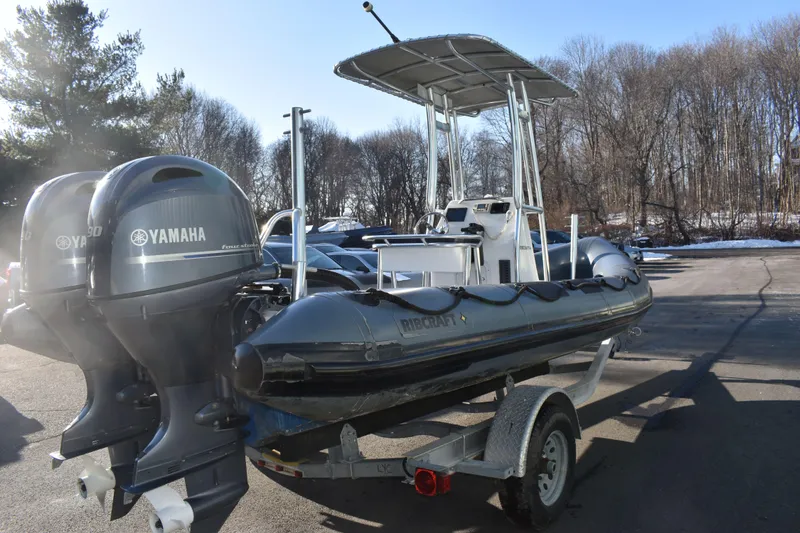 Slide: The Image of 2019 Ribcraft 6.5 boat with Yamaha engines on a trailer, parked outdoors. - 8