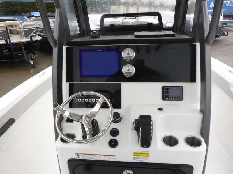 Slide: The Image of 2025 Sea Pro 242 Center Console boat dashboard with steering wheel and navigation controls. - 10