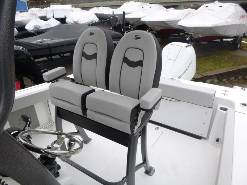 Slide: The Image of 2025 Sea Pro 242 Center Console boat seats with steering wheel, docked outdoors. - 11