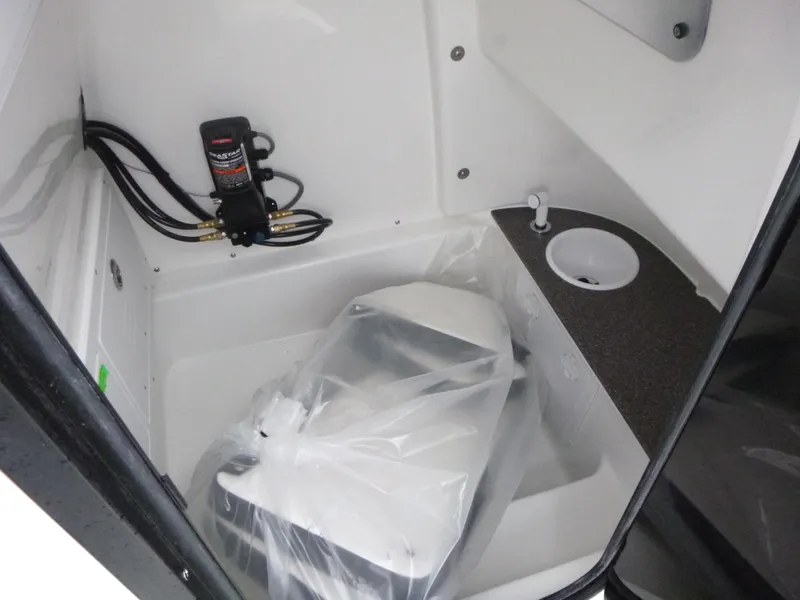 Slide: The Image of 2025 Sea Pro 242 Center Console boat interior with compact toilet and sink. - 18