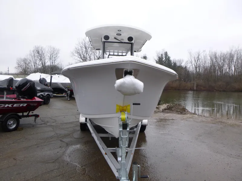 Slide: The Image of 2025 Sea Pro 242 Center Console boat on trailer by a riverbank. - 2