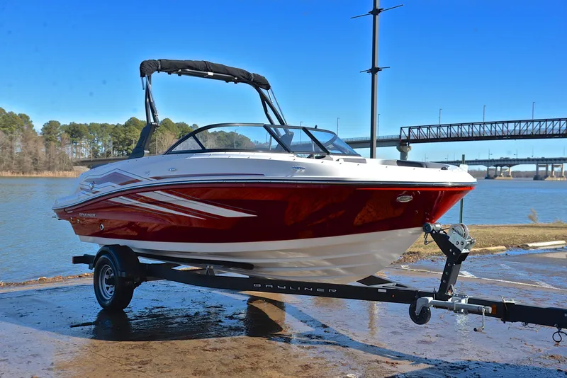 Slide: The Image of 2020 Bayliner VR5 boat on trailer by a lake with a bridge in the background. - 12