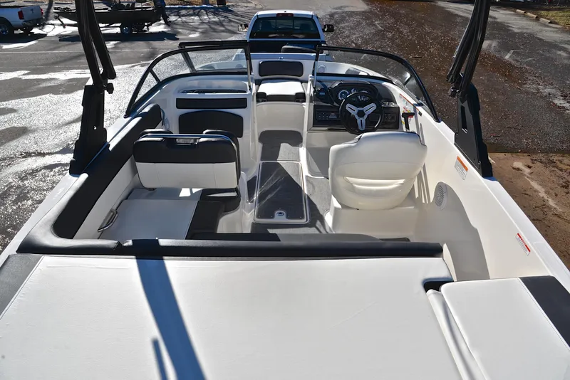 Slide: The Image of 2020 Bayliner VR5 boat interior with seating and steering wheel, parked on a trailer. - 14
