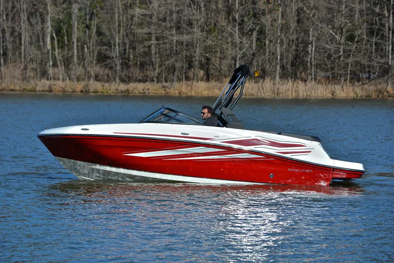 Slide: The Image of 2020 Bayliner VR5 boat cruising on a calm lake with forested background. - 5