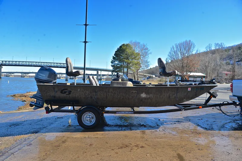 Slide: The Image of 2016 G3 Eagle 176 boat on trailer by river, bridge in background. - 15