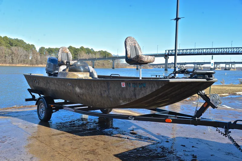 Slide: The Image of 2016 G3 Eagle 176 boat on trailer by a river, clear sky background. - 16