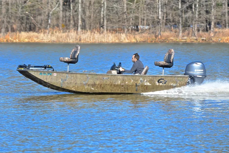 Slide: The Image of Man driving 2016 G3 Eagle 176 boat on a calm lake. - 2