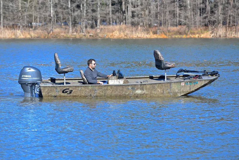 Slide: The Image of Man driving 2016 G3 Eagle 176 boat on a calm lake. - 7
