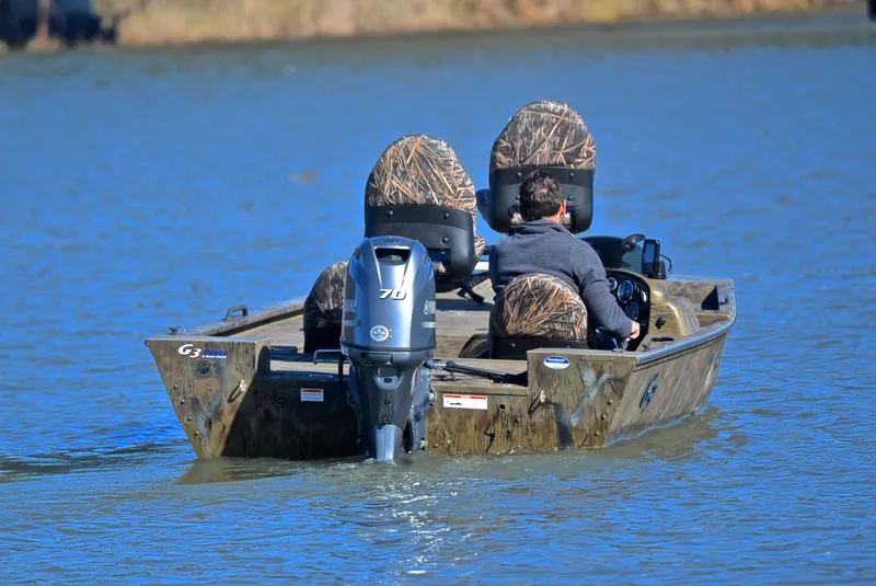Slide: The Image of 2016 G3 Eagle 176 boat on a lake with camo seats and outboard motor. - 8