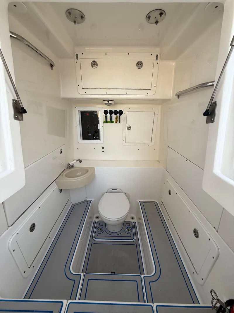 Slide: The Image of 2013 Invincible 42 Open Fisherman boat bathroom with toilet, sink, and storage cabinets. - 39