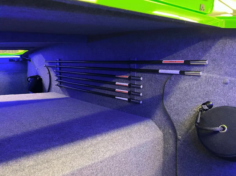 Slide: The Image of Interior of 2023 Daves Custom Boats M37R, featuring neatly stored rods on a carpeted surface. - 15