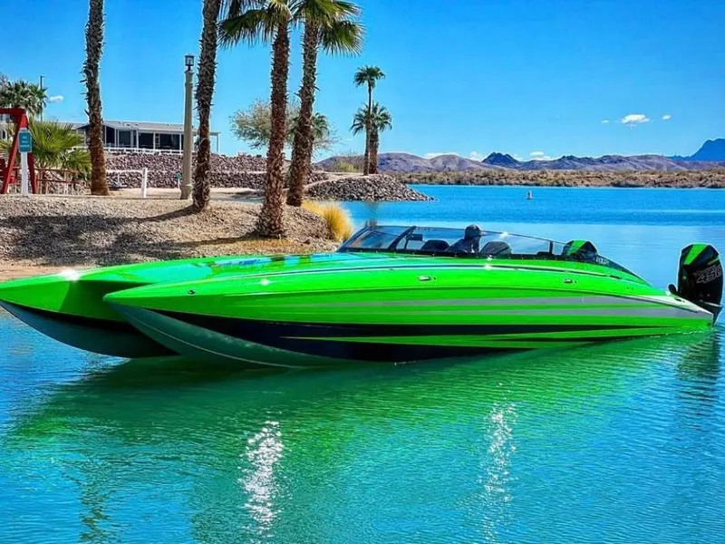Slide: The Image of 2023 Daves Custom Boats M37R in vibrant green on a serene lake. - 3
