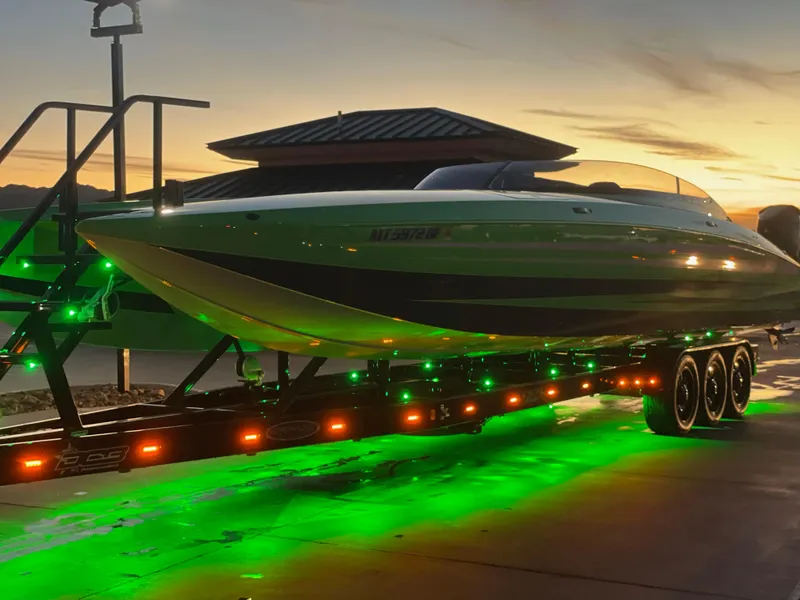 Slide: The Image of 2023 Daves Custom Boats M37R on trailer with green lights at sunset. - 6